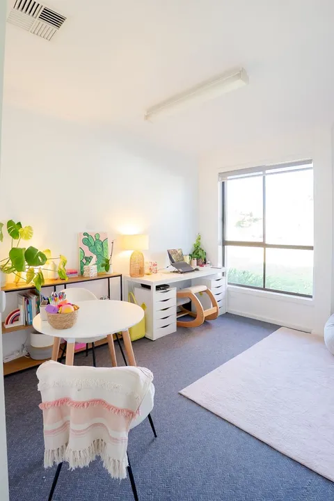 Light-filled therapy room with a desk, round table and comfortable seating