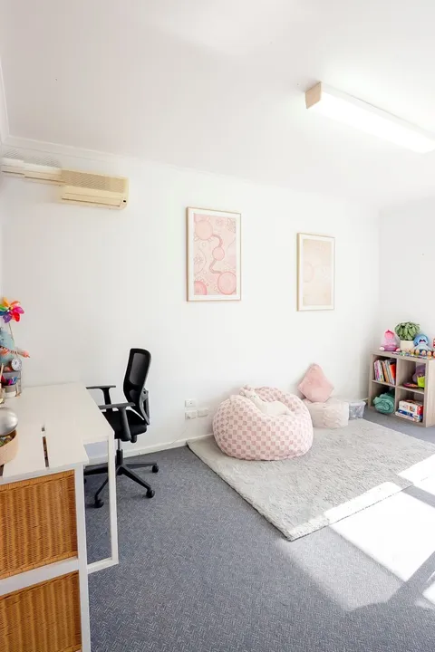 Therapy room with a desk, beanbag seating and shelves of play resources